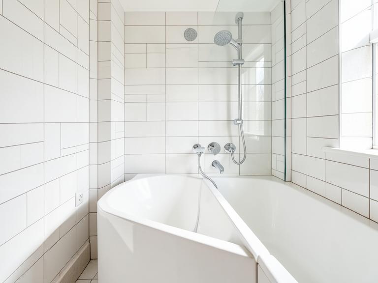 Renovated white-tiled bathroom